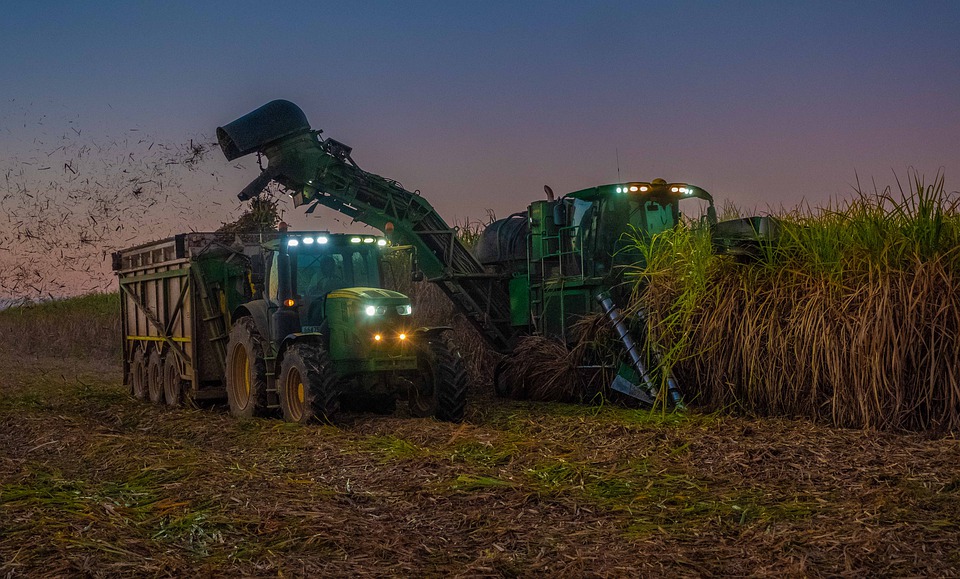 LED Arbeitsscheinwerfer am Traktor und Mähdrescher im dunklen Feld